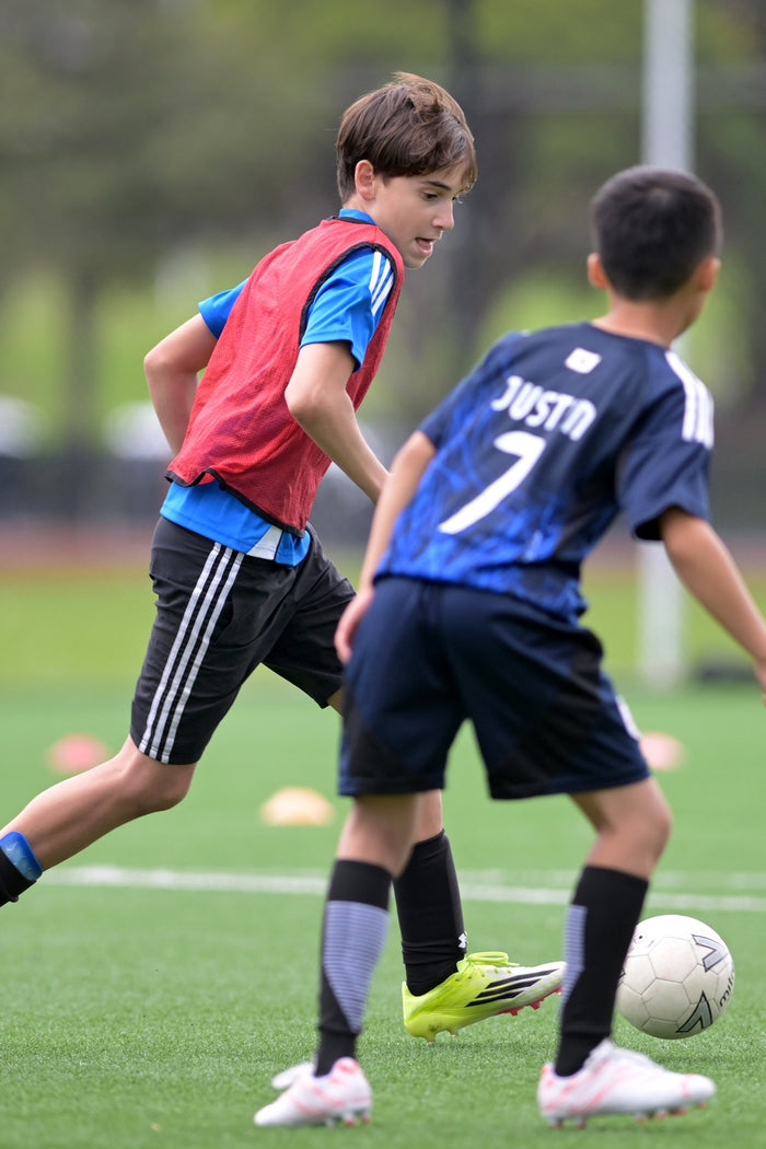 Two children putting their skills into action during match play at an ASC soccer camp