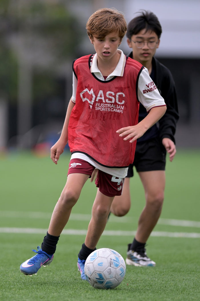 Two boys playing soccer at an ASC soccer camp