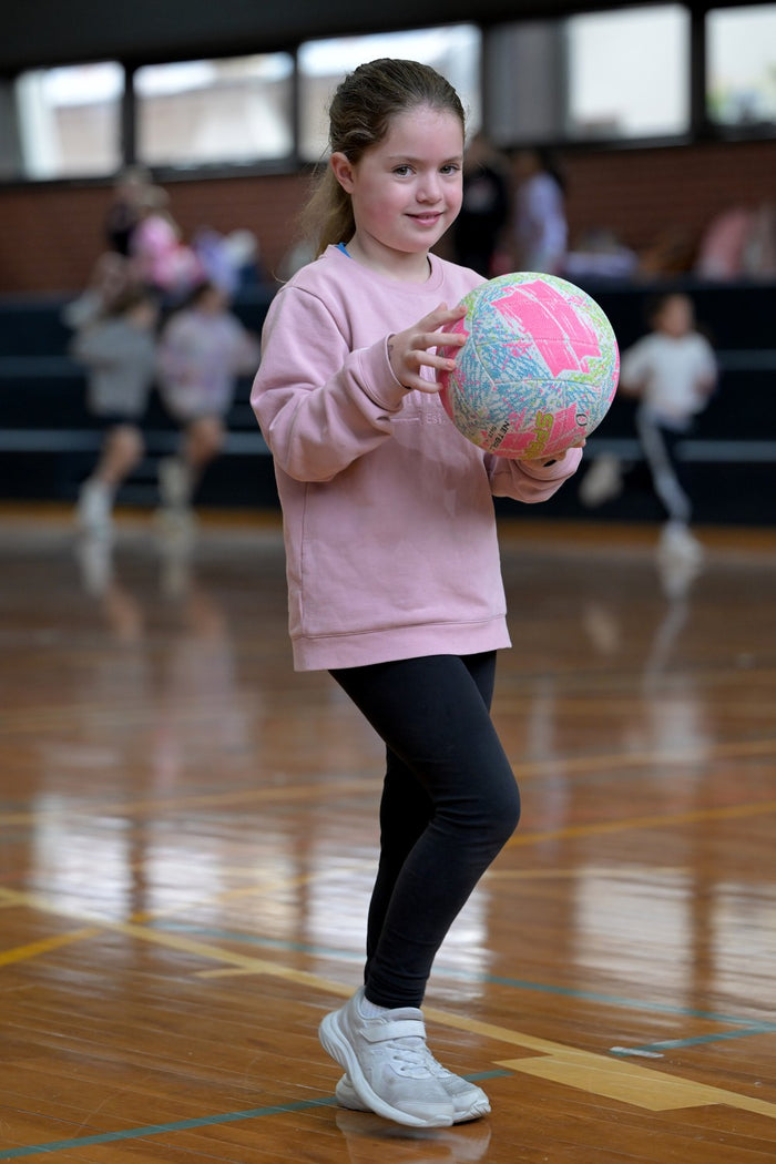 A smiling young girl at an ASC netball camp