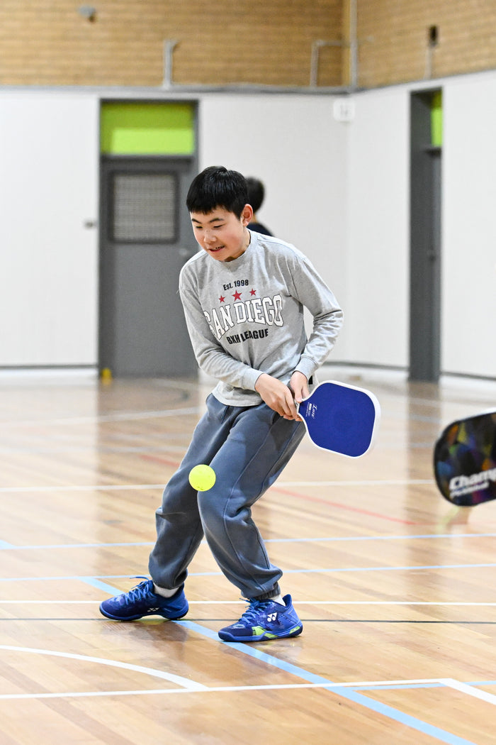 Boy about to return serve at an ASC pickleball camp