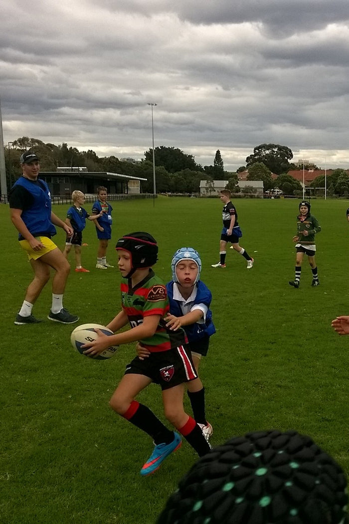 Young boy about to tackle another young boy at an ASC rugby league camp