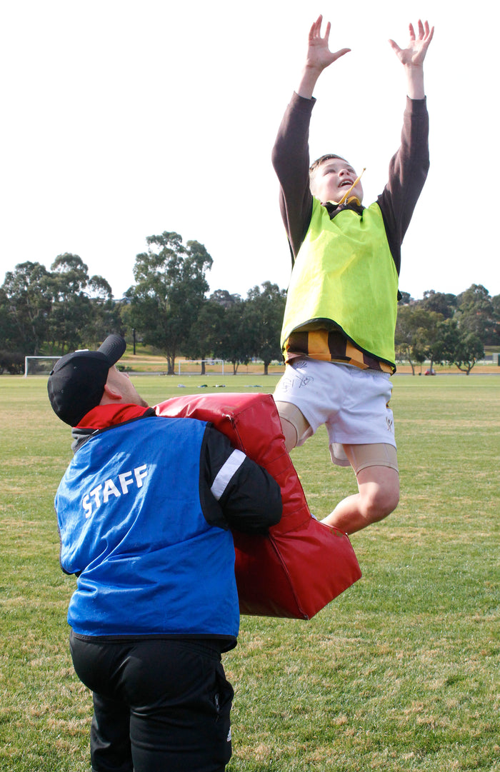 Young boy practising marking at an ASC AFL/AFLW sports camp