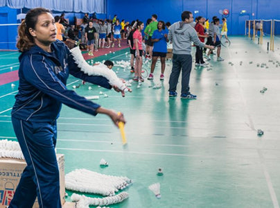 Coach providing hitting practice at an ASC badminton camp
