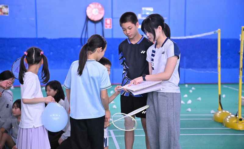 Students at an ASC badminton camp receiving instructions from their badminton coach.