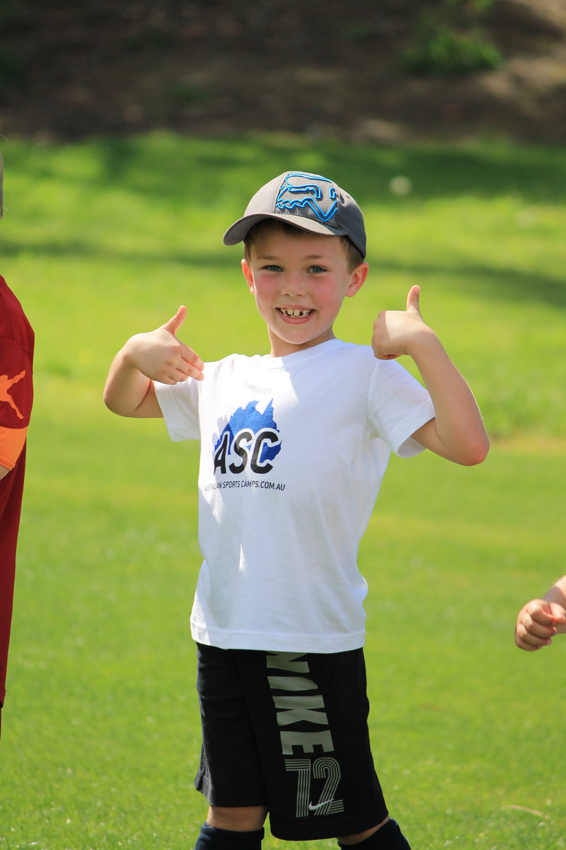 A very happy smiling young boy at an ASC sports camp. Two thumbs up!