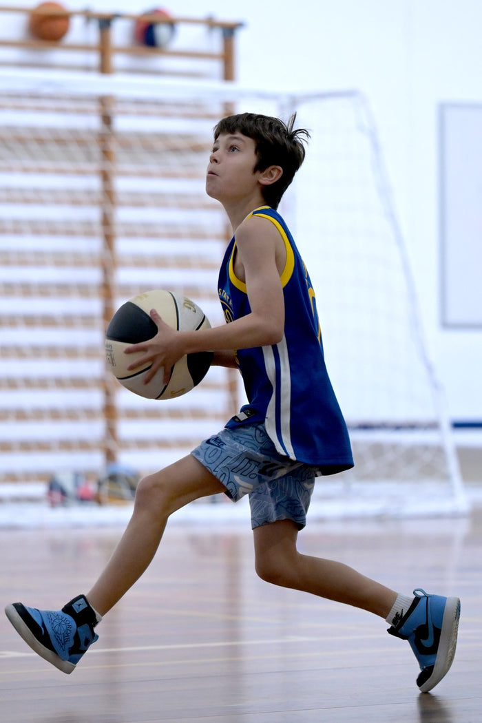 Boy at an ASC basketball camp getting ready to shoot