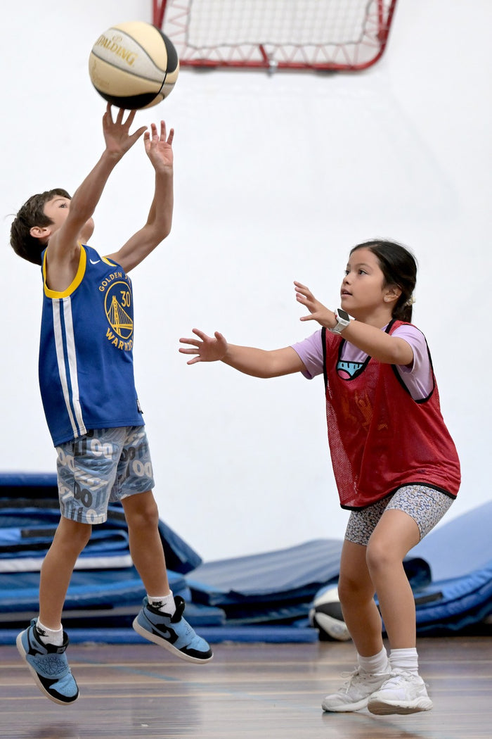 Young boy and girl practising their attacking & defencive skills at an ASC basketball camp