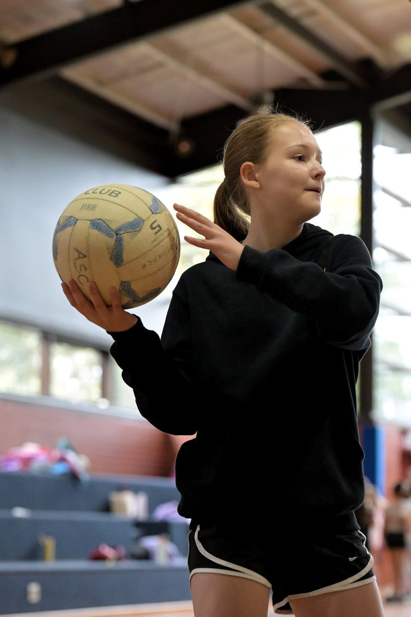 Young girl practising passing skills at an ASC netball camp