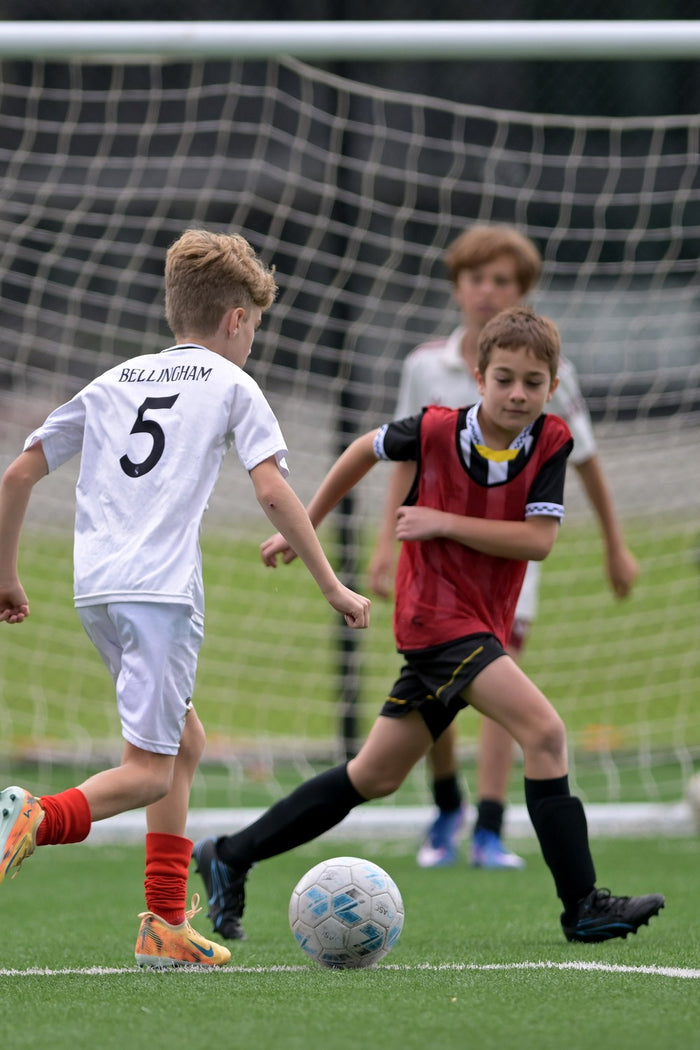 Two boys contesting the ball at an ASC soccer camp