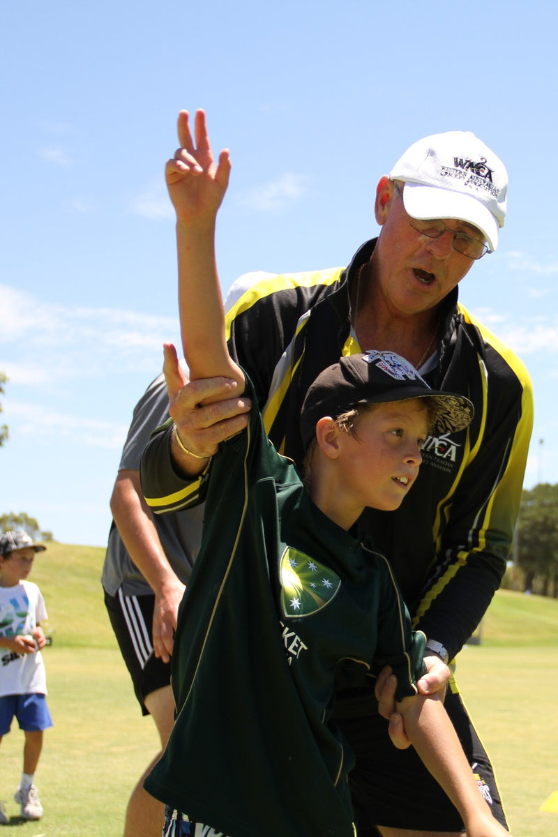 Young boy receiving expert bowling tuition at an ASC cricket camp in Perth