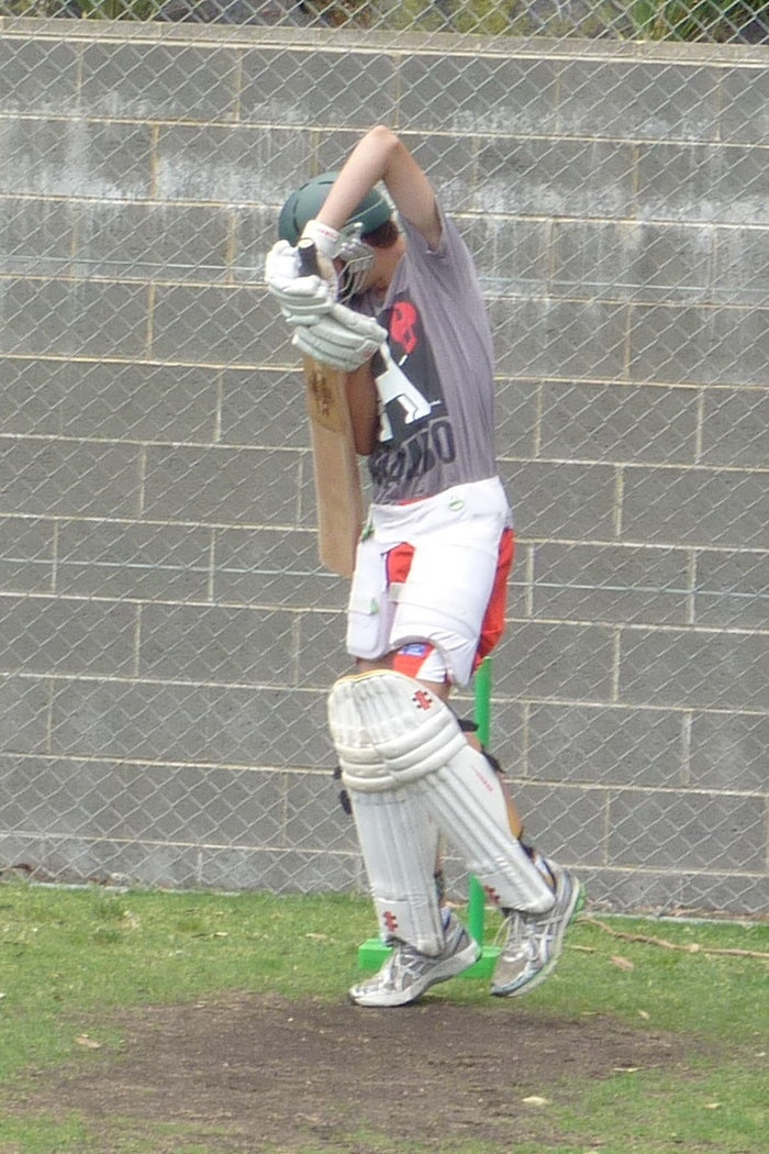 Young male practising his batting skills during a net session at an ASC cricket camp