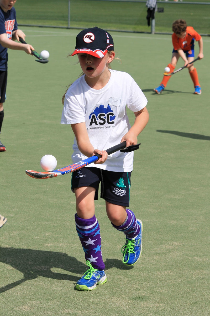 A young girl practising field hockey ball control skills at an ASC hockey camp