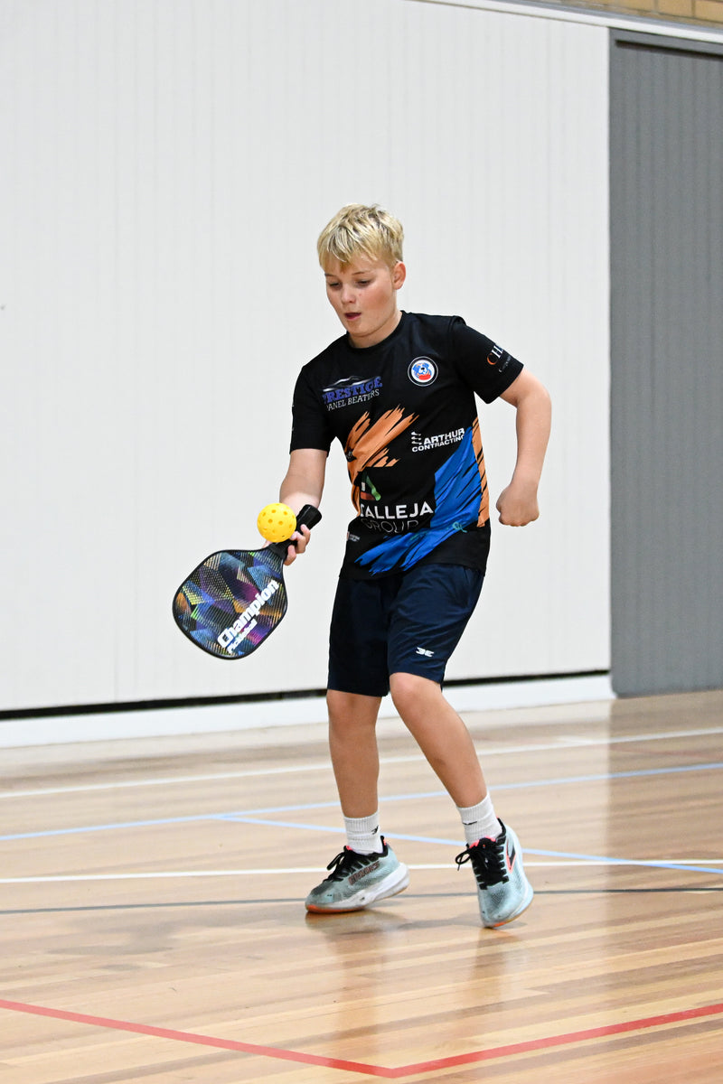 Boy hitting a return shot at an ASC pickleball camp.