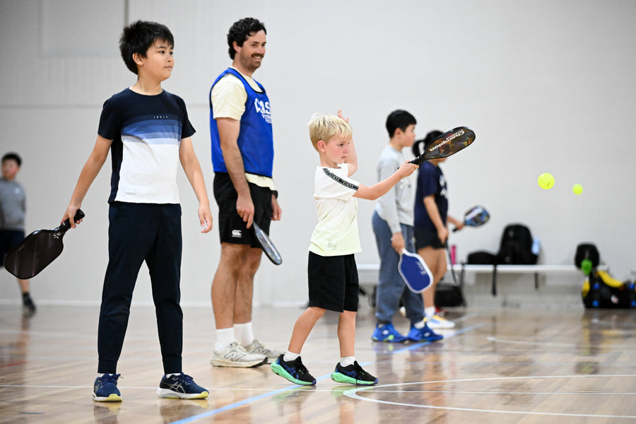 ASC coach looking on with delight at the progress of his students at an ASC pickleball camp