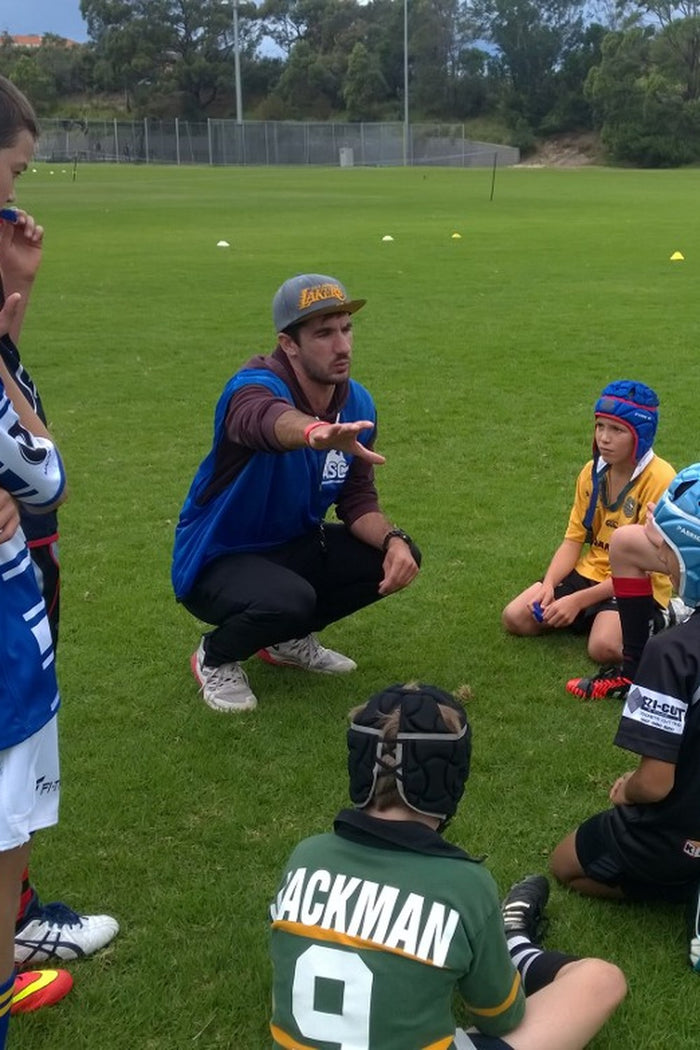 Coach discussing a drill with a group of boys at an ASC rugby league camp